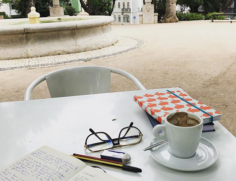 A table in the park with notebook and empty coffee cup
